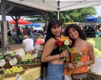 Me and my friend holding flowers at the farmer's market