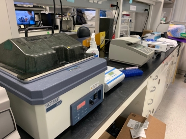 Photo showing a wet lab bench with PCR machines for biology research