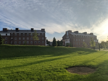 A sunny-scene outside of Anonymous Hall overlooking a grassy lot