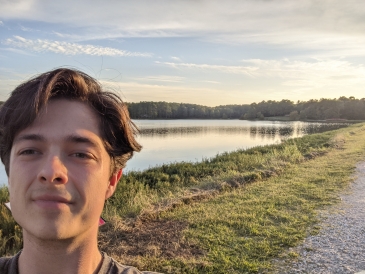 Me taking a selfie in front of a local lake enjoying the sunset