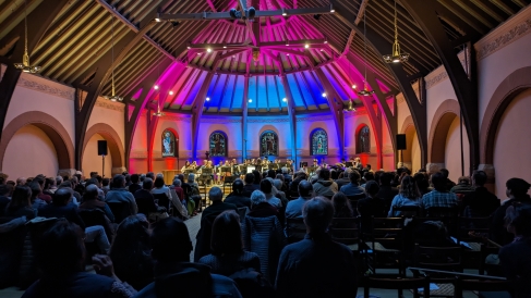 Coast Jazz Orchestra Performance happened in Rollins Chapel while the HOP is undergoing renovations. People sat in the normal seating and behind the performers there were colored spotlights facing the ceiling.