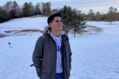 Robin smiling for a photo against a winter landscape