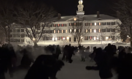 The snowball fight commences with snow everywhere. Dartmouth Hall is seen in the background, with countless students in the foreground. No clear subject of the photo; too dark to see much at all.