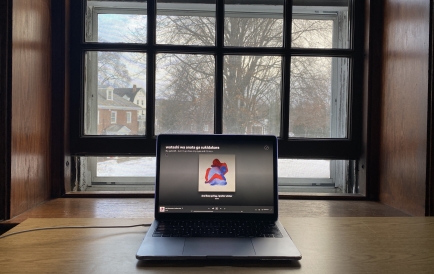 Picture of Gabriel's study setup, featuring a MacBook on a desk overlooking a snow-covered campus.