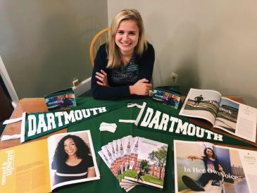 Ali sitting at a college fair table