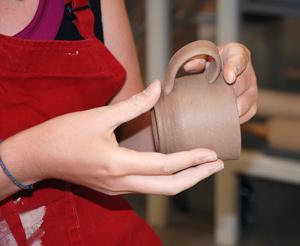 student holding ceramics cup