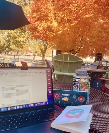 The view as I study on Collis patio -- I have my laptop, water bottle, pencil pouch, and a book out, and there's a beautiful tree in the background.