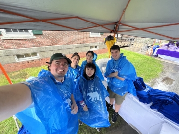 North Park UGAs in blue ponchos welcoming 27's to campus