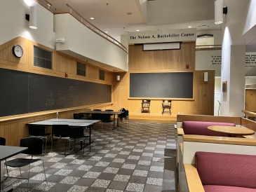Picture of a large room dominated by a long chalkboard and a row of diner-style booth seats.