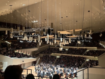 An image of an orchestra in an huge theatre with a crowd