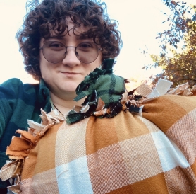 Selfie of me and a pillow shaped like a pumpkin
