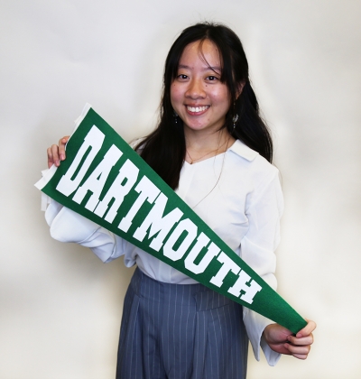 Student smiling holding Dartmouth banner
