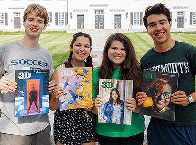 A photo of four students holding issues of 3D Magazine in front of Dartmouth Hall