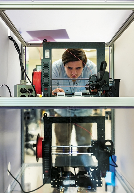 A photo of Trevor Gittes Taplin '25 operating a 3D printer at the Cable Makerspace