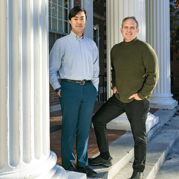 A photo of Carson Goh '25 and Jason Barabas '93 standing in front of white columns