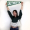 Student smiling for photo holding Dartmouth pennant over head