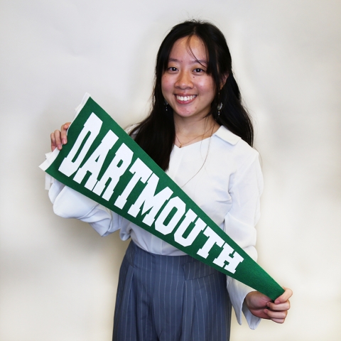 Student smiling holding Dartmouth banner