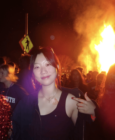 Youmi smiling and standing in front of the homecoming bonfire