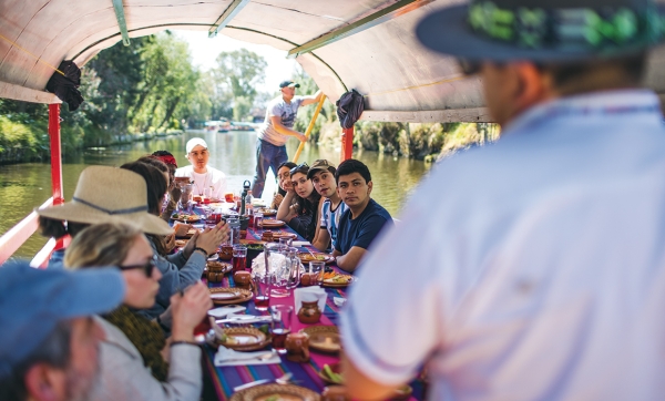 A photo of Dartmouth students on a boat at the Xochimilco Ecological Park and Plant