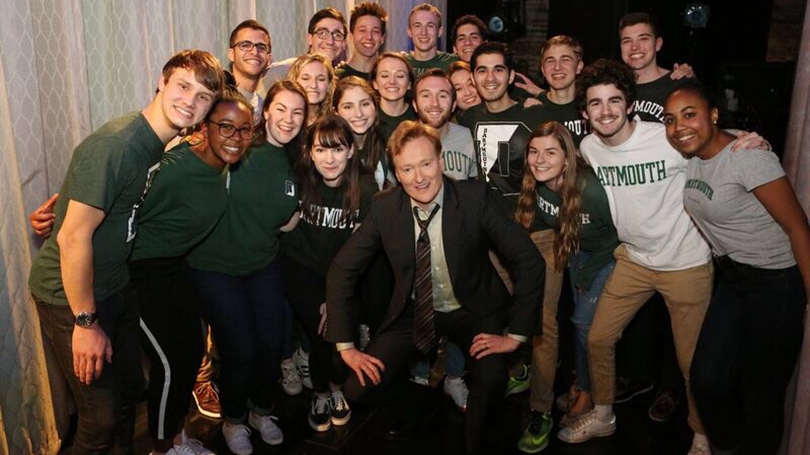 Conan O'Brien surrounded by students in Dartmouth shirts