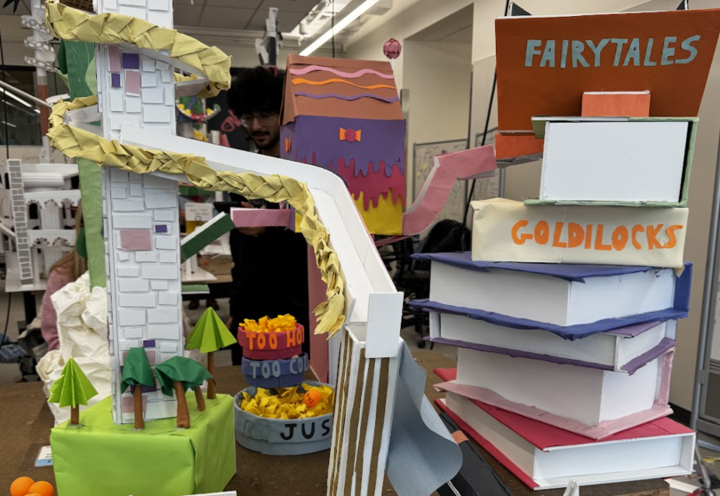 Image featuring a roller coaster built out of foam core. The rollercoaster features several elements from different fairy tales such as a stack of books, Hansel and Gretel's Candy House, Rapunzel's tower, Captain Hook's ship, and more. The roller coaster