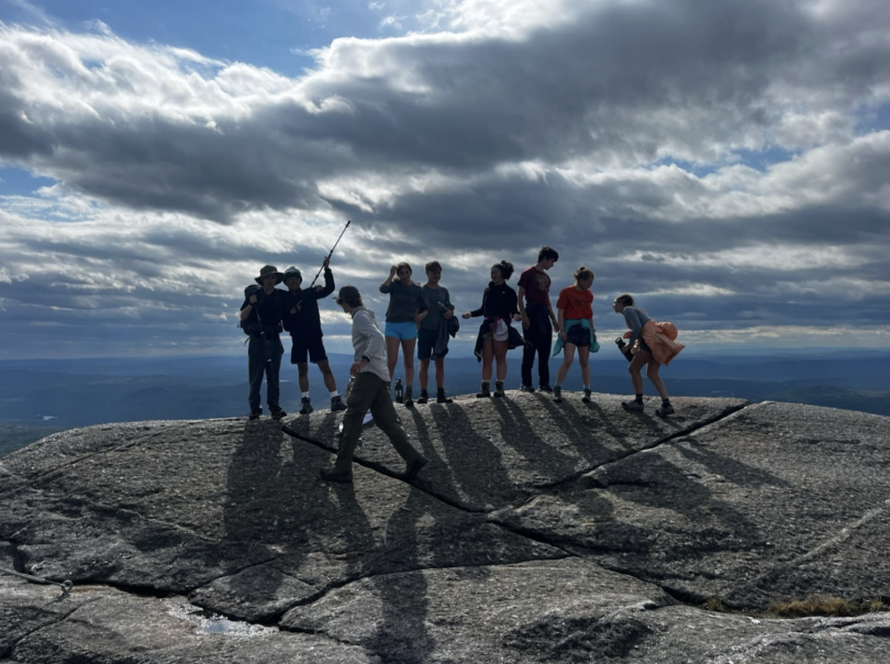 A group of Dartmouth students celebrating at the summit of a hike!