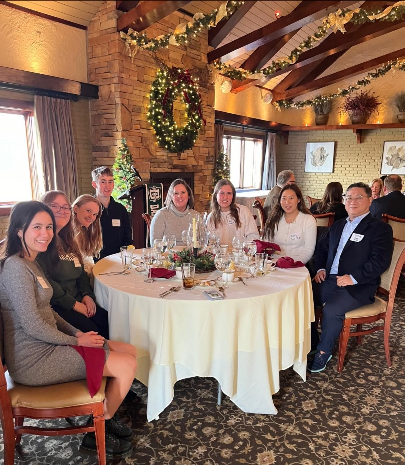A photo of me, Lauren, along with current Dartmouth students. We are sitting around a table and wearing business casual clothing.