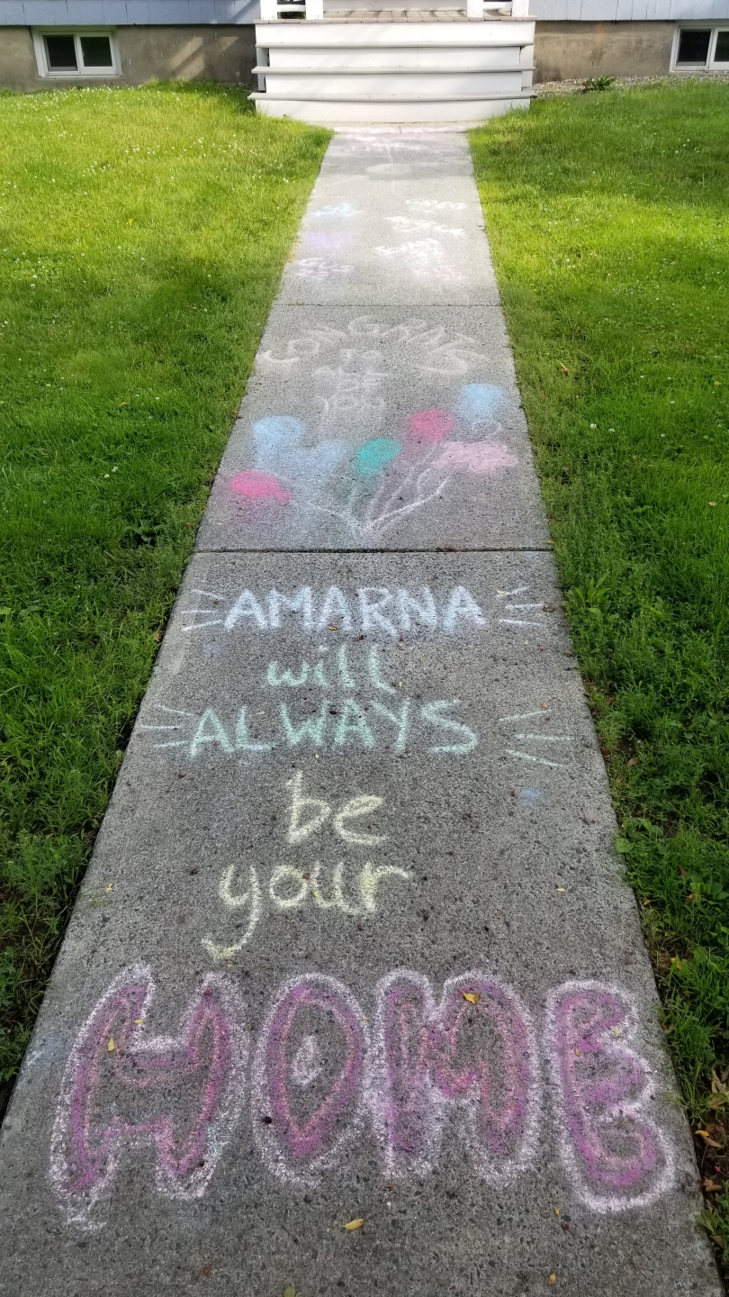 Chalk art on the sidewalk in front of Amarna that says: "Amarna will always be your home"