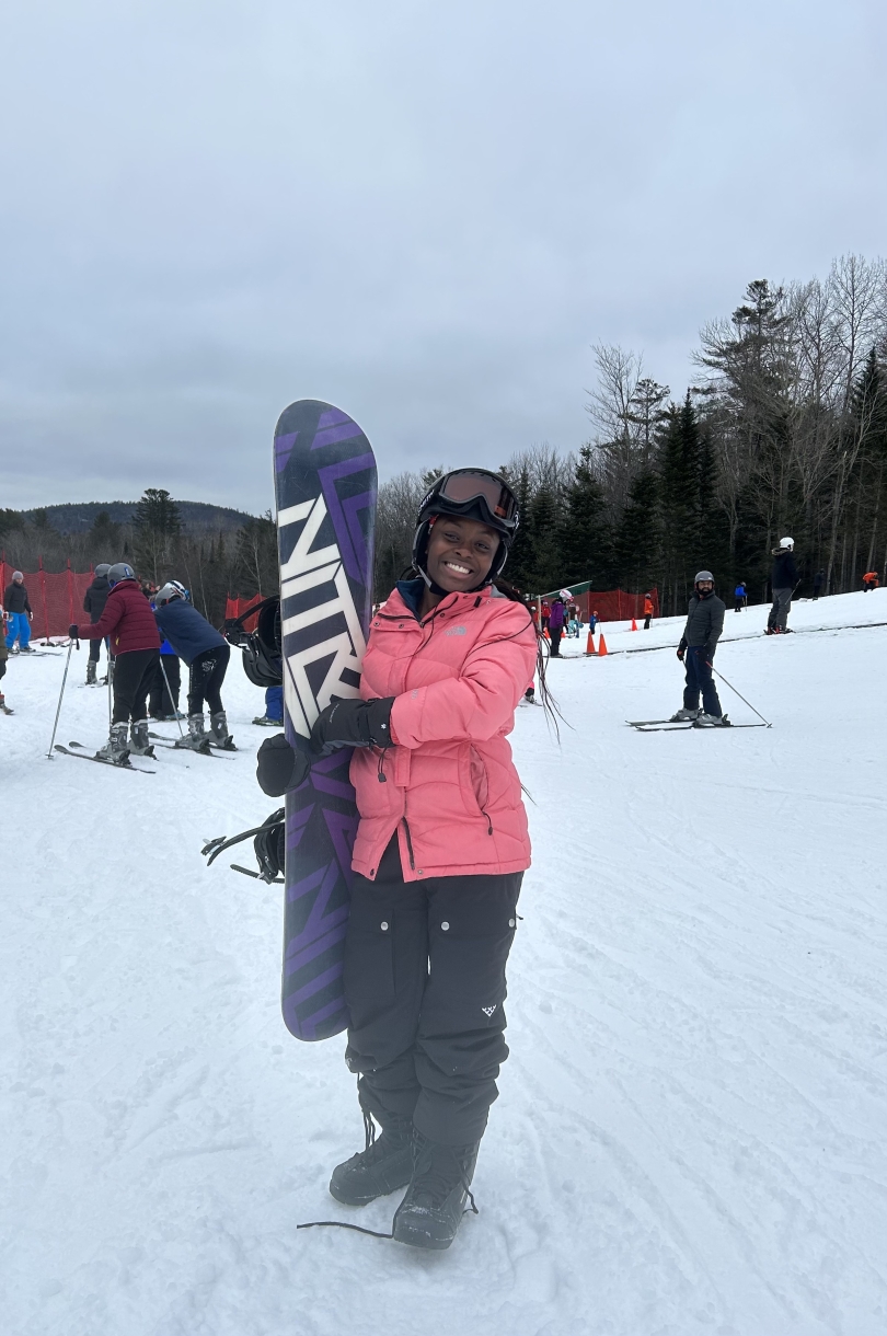 Woman holding snowboard on a ski mountain 
