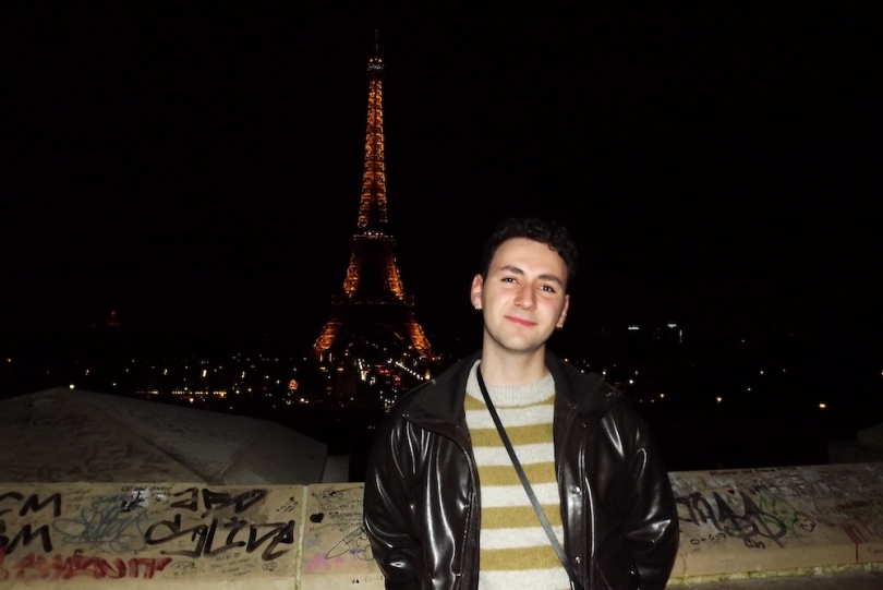 Blogger standing in front of the Eiffel Tower at night