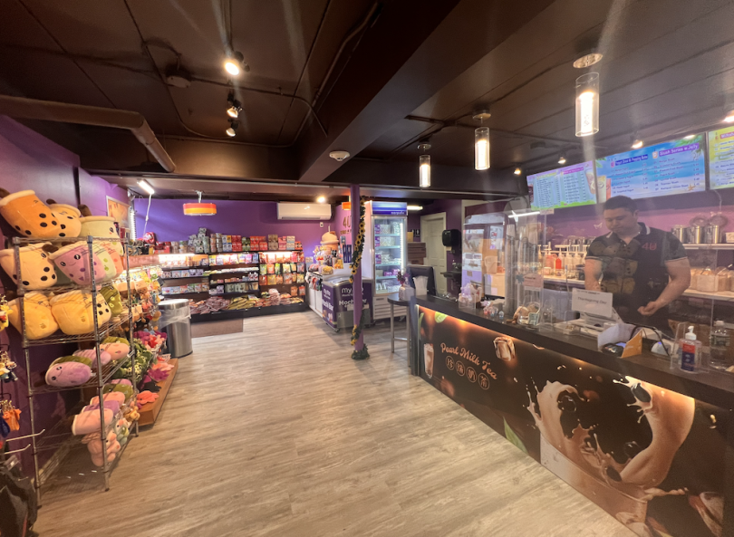 Interior of the store with purple walls, plushies, candies, and the counter where the boba is made to the left