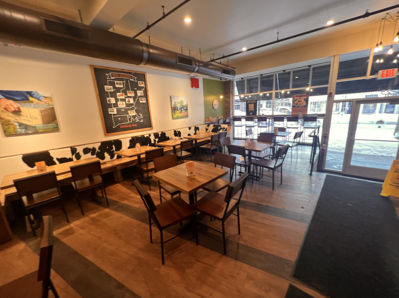Seating area of The Works, multiple 4-people tables and individual seating options by the window.