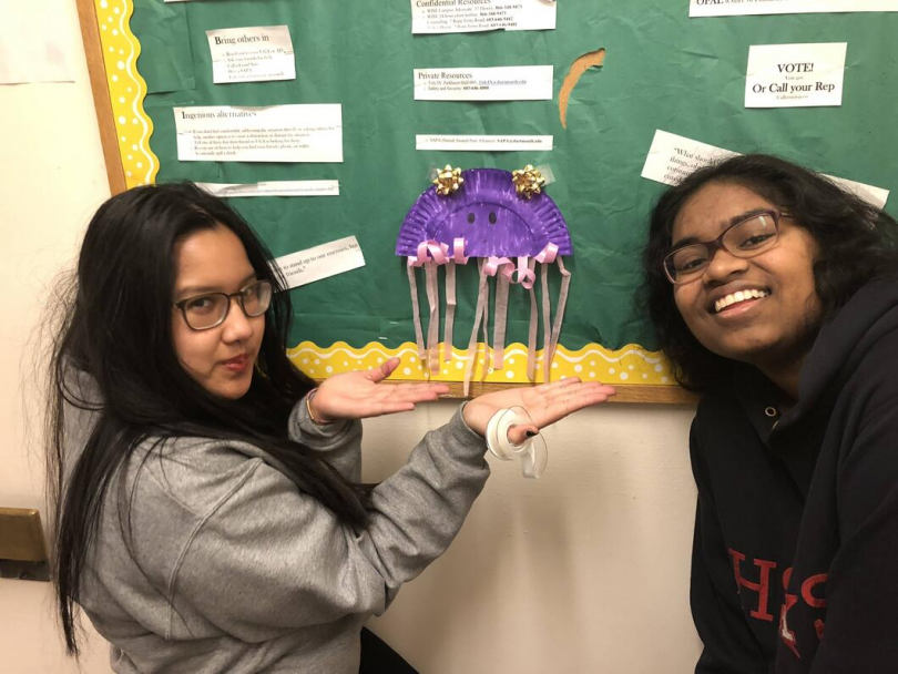 Angie and her freshman roommate posing with a decoration on their freshman UGA's bulletin board.