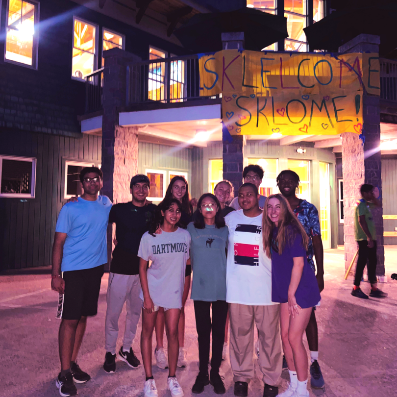 Group photo of Dartmouth students in front of the Ski Lodge at night 