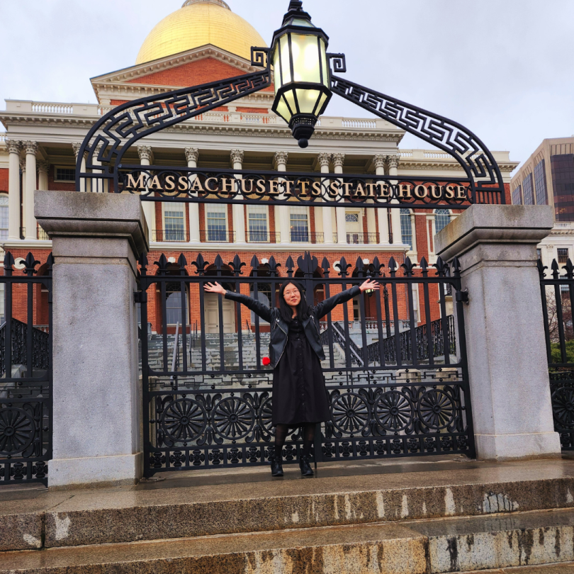 person posing at the front of massachusetts state house 