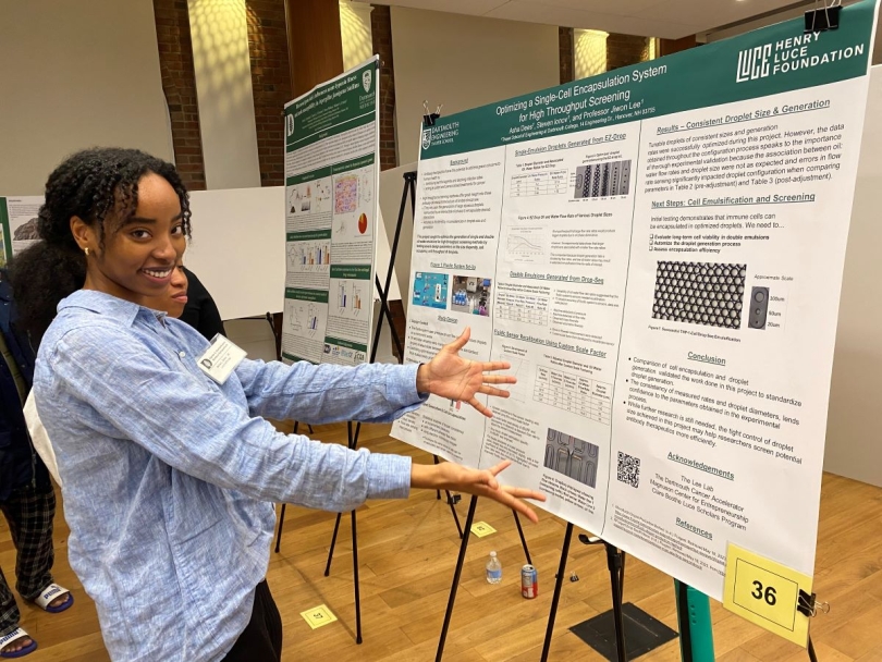 A picture of a fellow researcher presenting her poster.