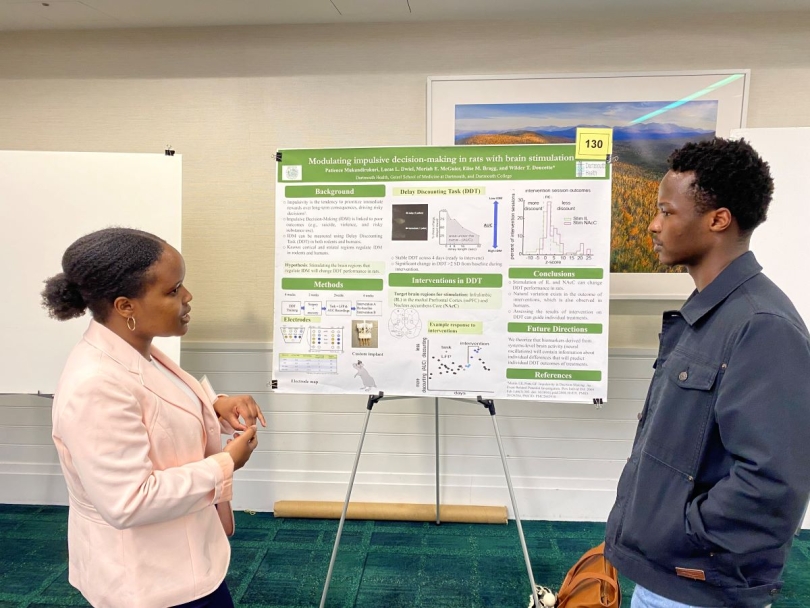 A picture of a student presenting her research to an audience.