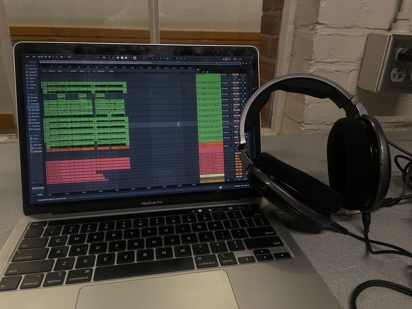Picture of a music software on a laptop with headphones leaning against the screen