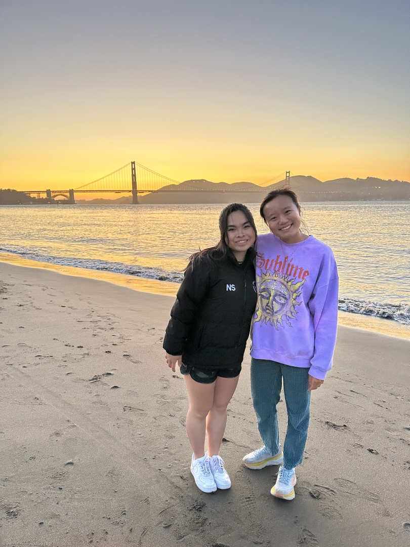 Ningning and I smile for a picture by beach watching the sun set over the Golden Gate Bridge.