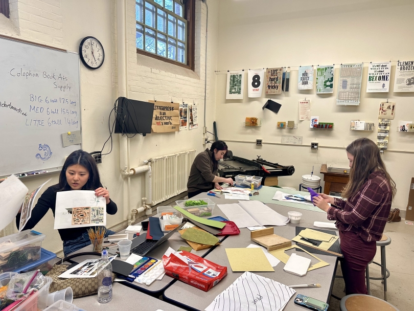 Three students are hard at work on their zines at the Book Arts Workshop Studio