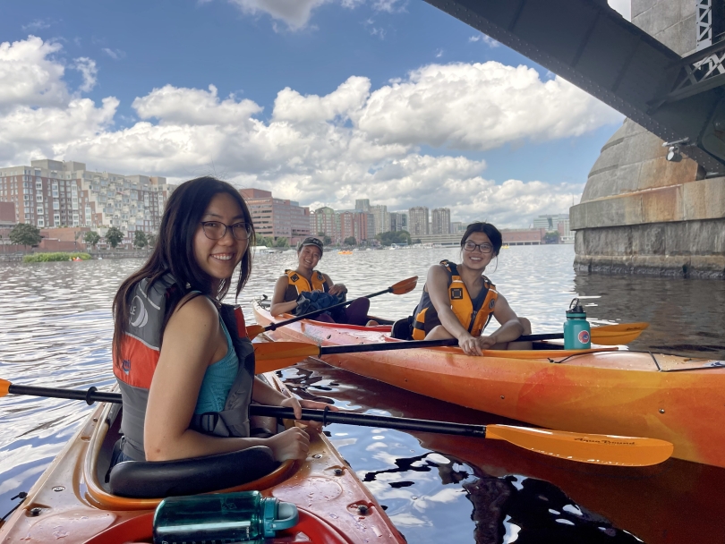 Alex '24, Diana '24, and I smile for a picture under a bridge in Boston's Charles River.