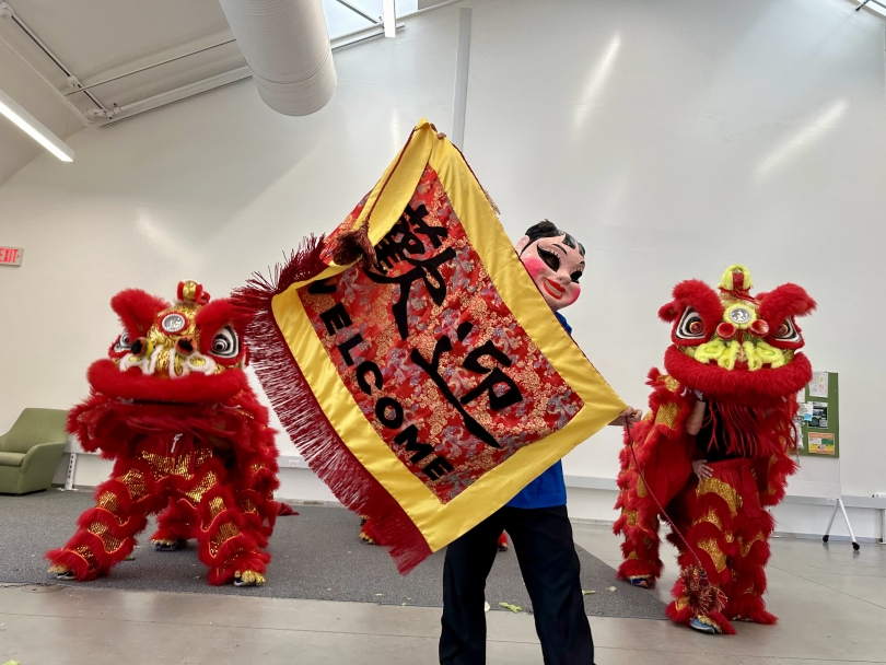 In The Onion, one of Dartmouth's housing community spaces, an all-female lion dance group performs. Two red and yellow lions perform with a masked woman holding up a "Welcome" sign.