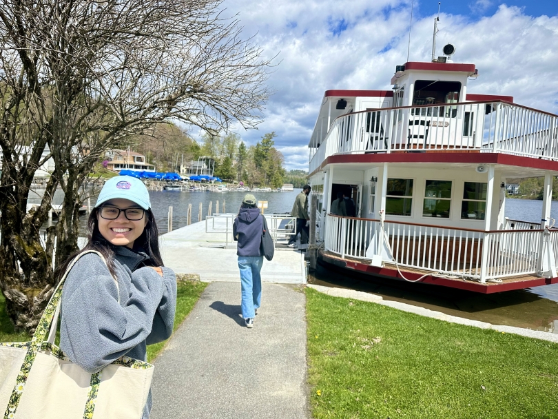My friend Diana smiles for a photo on the way to boarding a two-story red and white boat on a lake in NH.