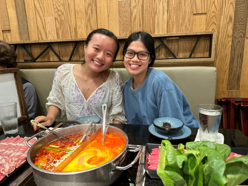 Diana and I smile for a photo as we are about to enjoy our tomato and spicy broth, veggies, and meats at hot pot.