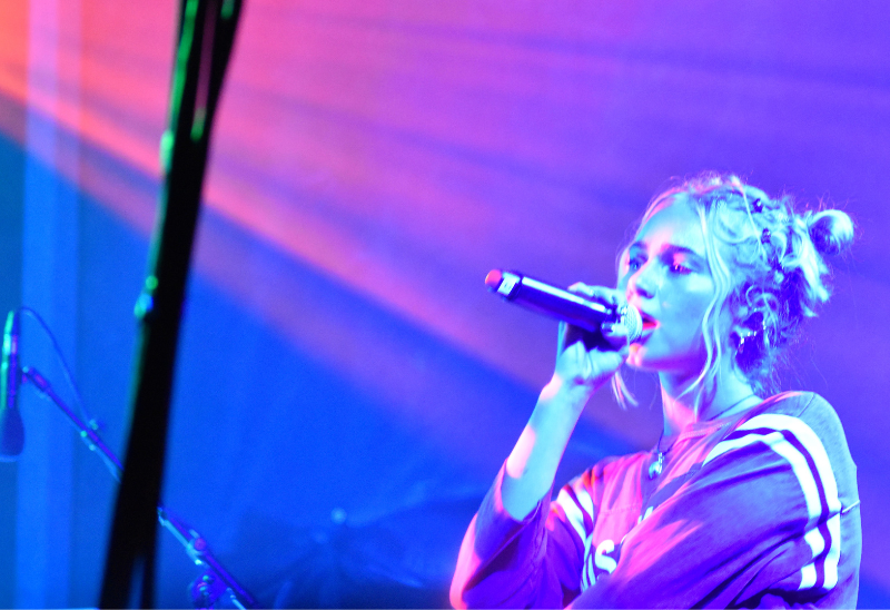 Claire Rosinkranz singing while holding a mic