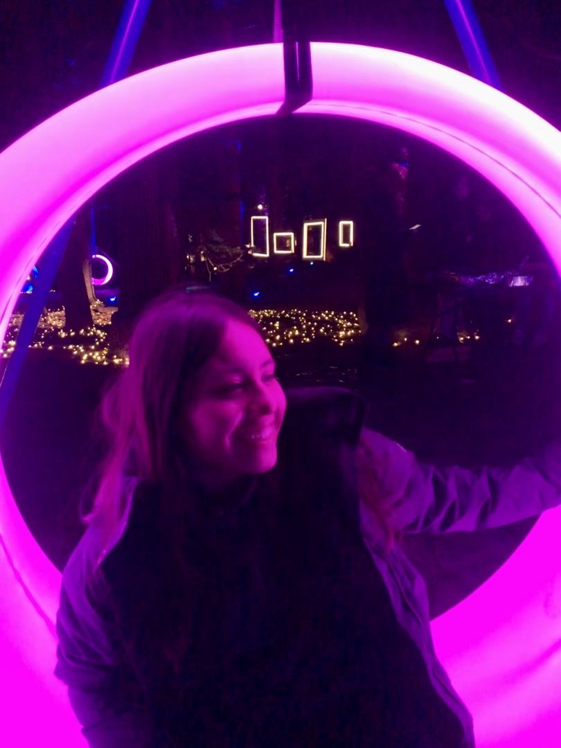 Reina '23 sitting on a swing during BEMA Lights, a winter tradition