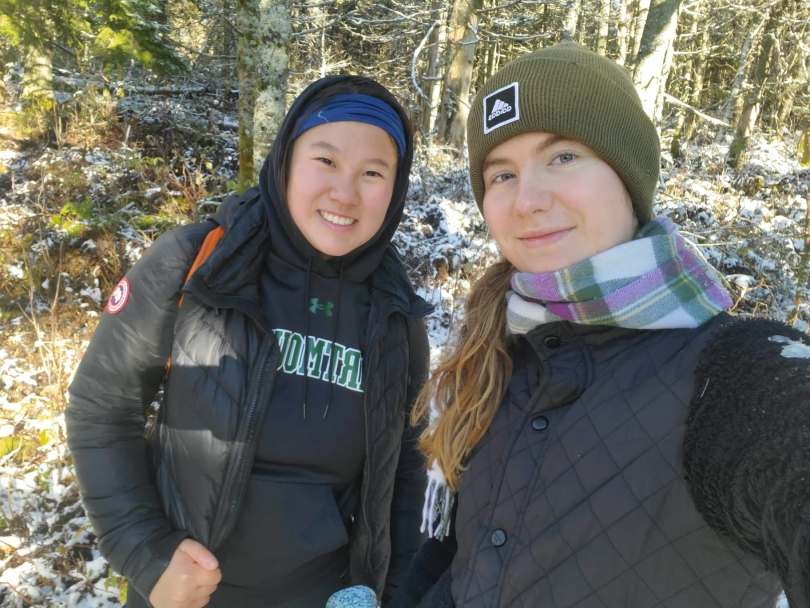 Me with my friend on a mountain top after a morning hike, there is some snow on the ground from the prior night.