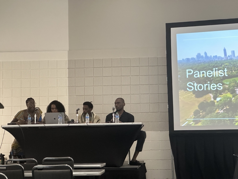 Panelist Speakers sitting down next to a presentation titled "Panelist Stories"