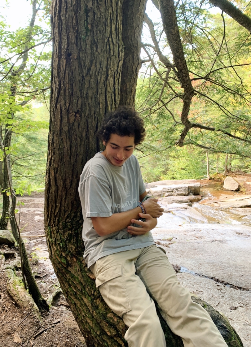 A picture of me sitting on a tree while on a hike.