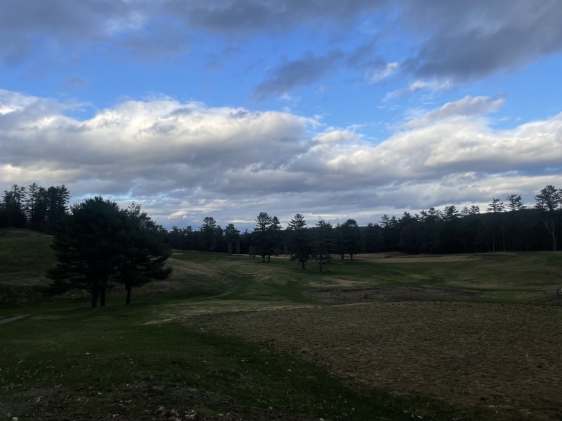 A picture of large, green hill on the Dartmouth golf course near the end of the Occom Pond walking loop